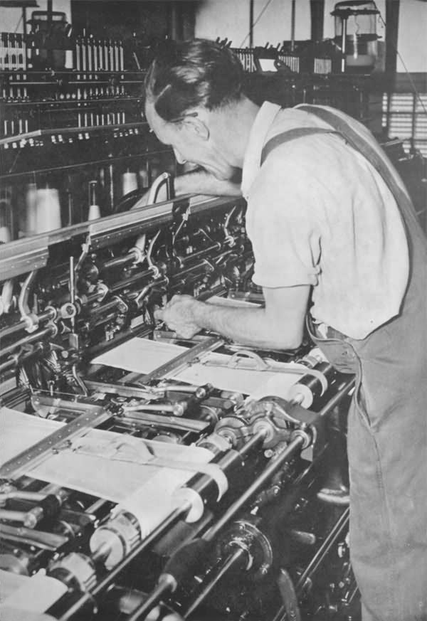 A knitter adjusts his machine